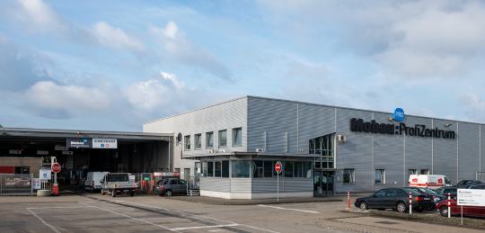 Gebäude mit Schwarz Blauem Mobau Profizentrum und Parkplatz mit Autos in Dremmen